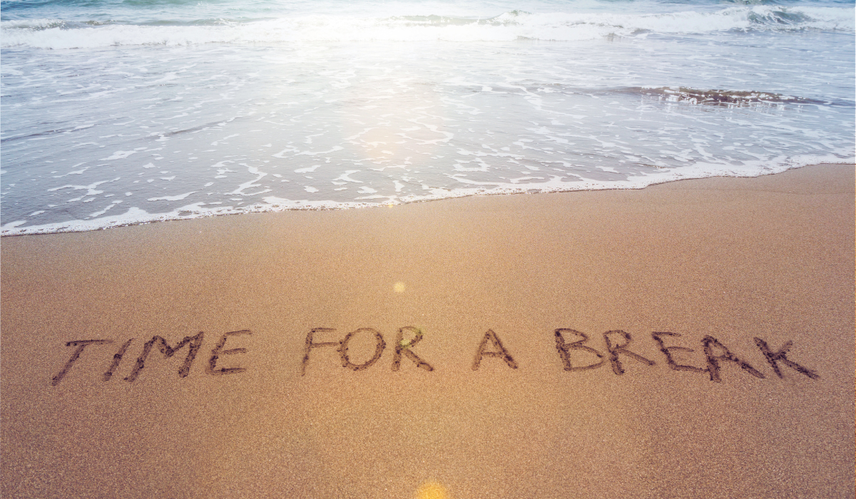 beach photo with writing in the sand that says TIME FOR A BREAK