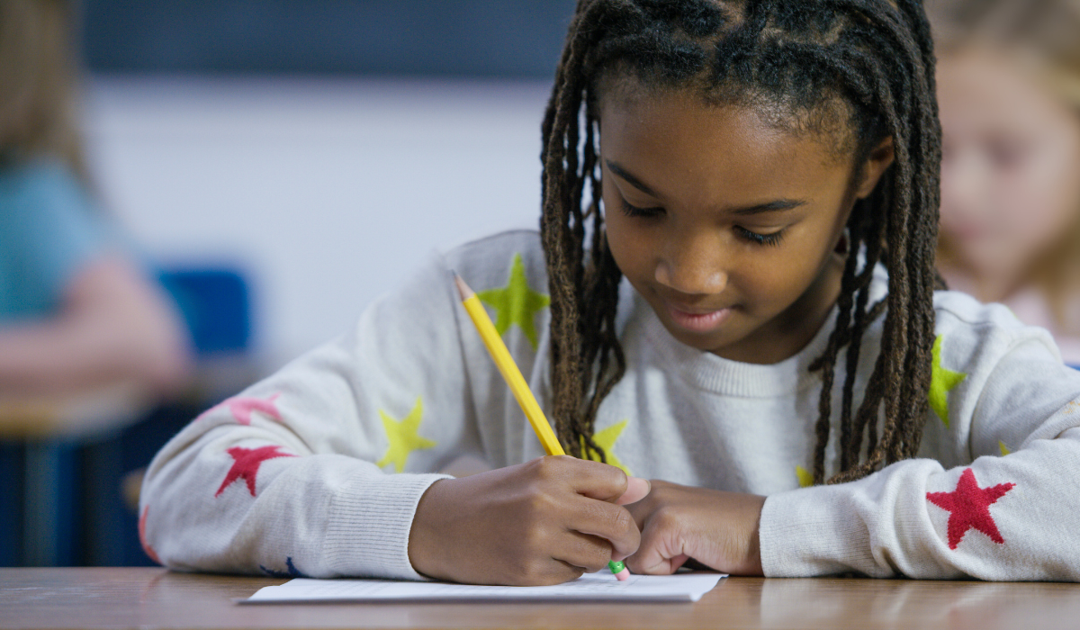 a little girl taking an eraser to an answer on her test