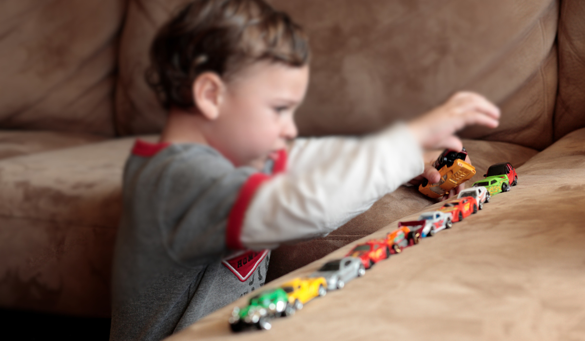 child with autism lining up toy cars