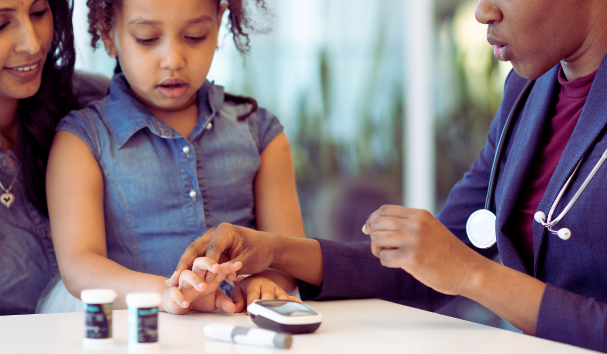 child being shown fingerstick by her doctor