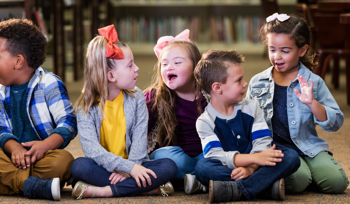 children talking in class, one girl with down syndrome