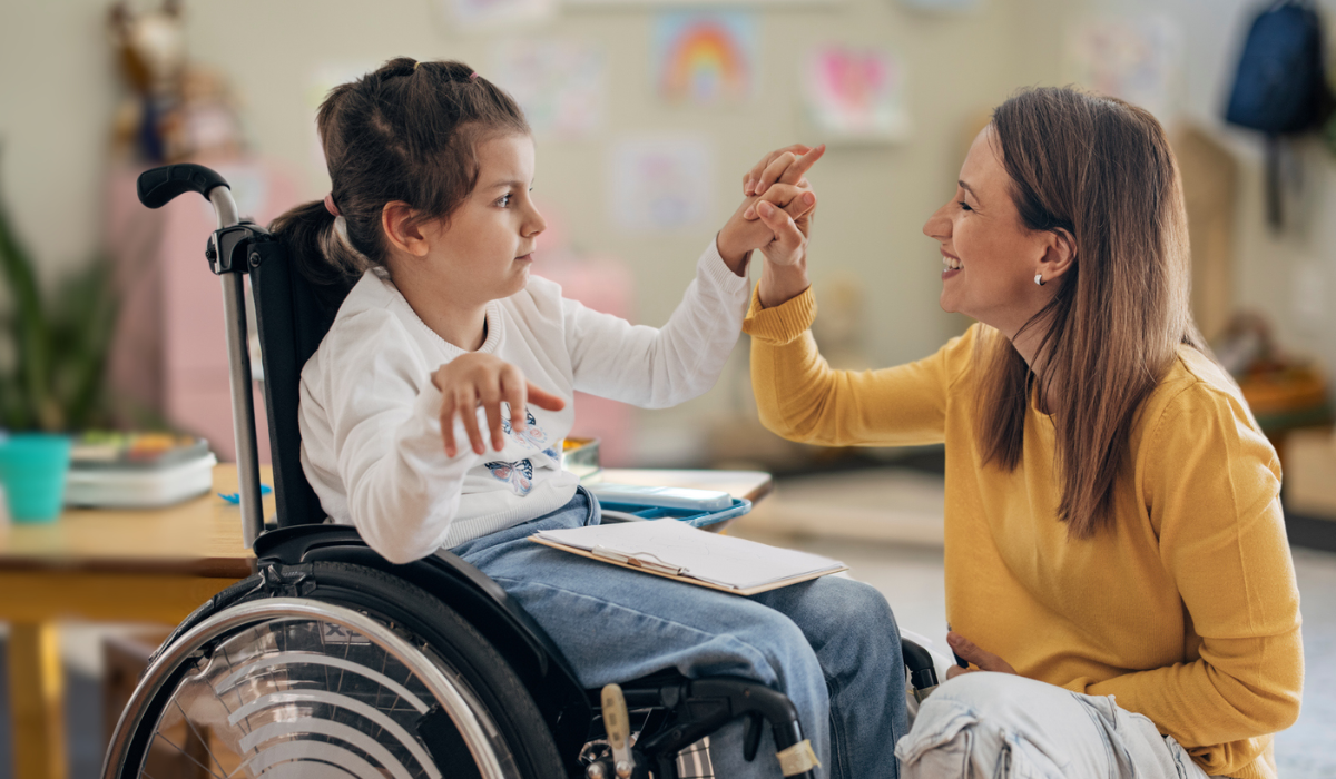 student in a wheelchair working with her teacher