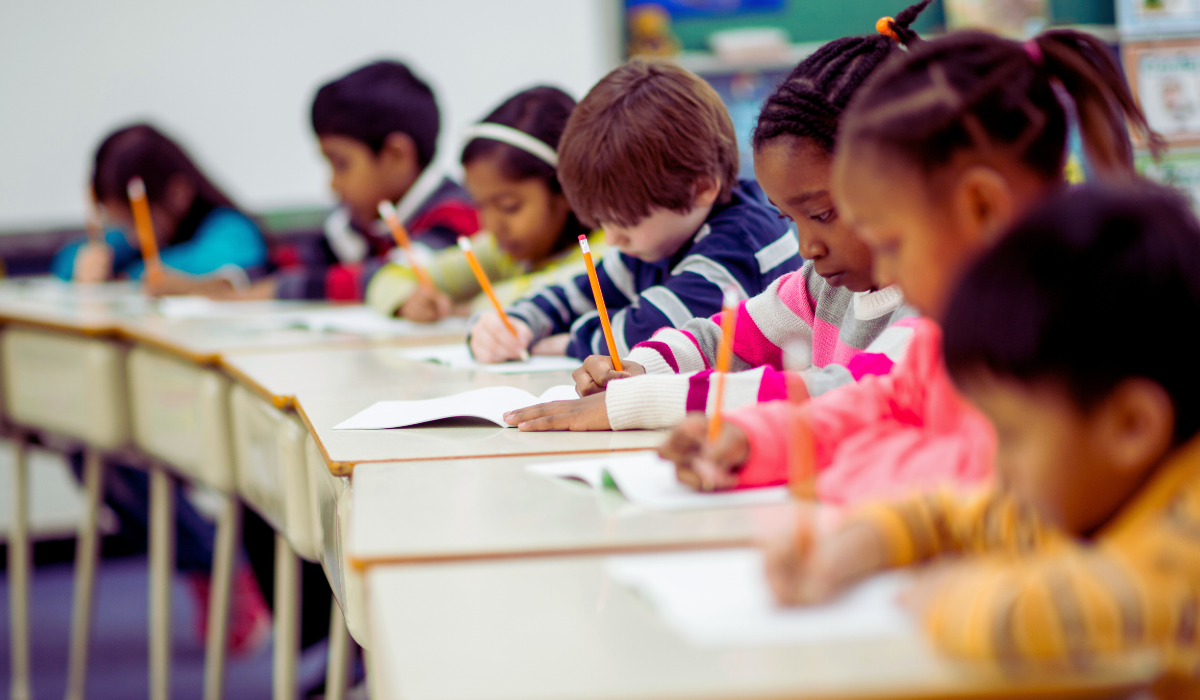 photo of a row of third graders at their desk working on a paper