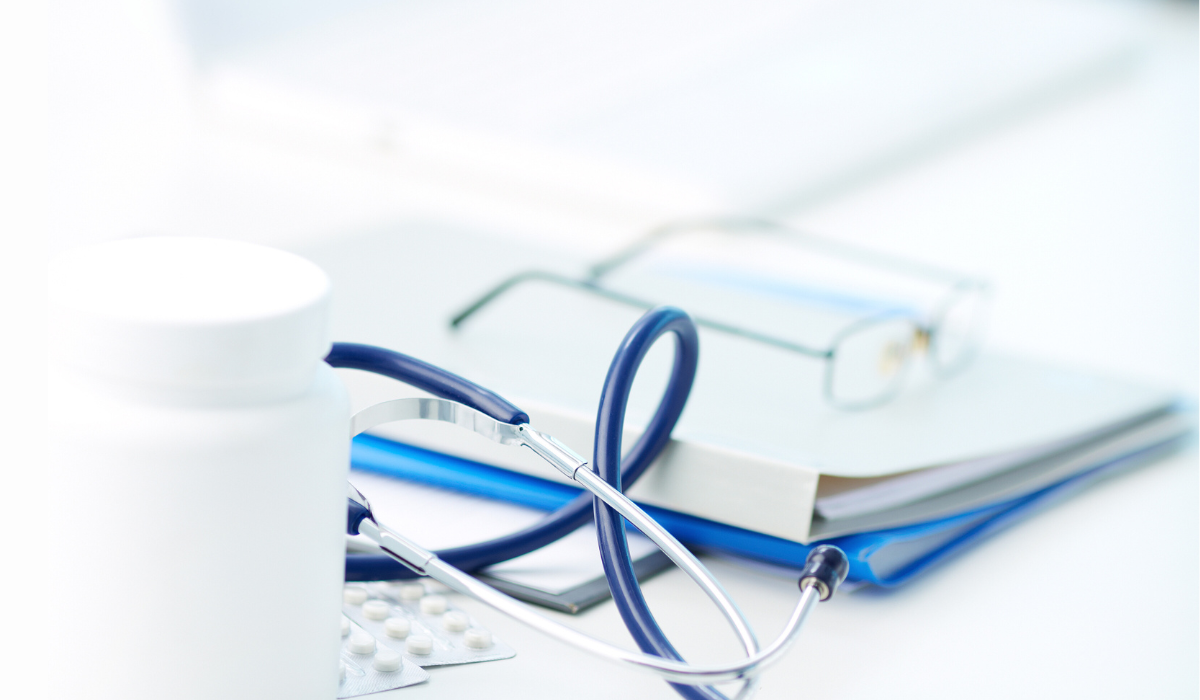 photo of stethoscope, prescription pad, pills, computer, glasses